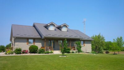 Hy-Grade-Steel-Roofing-System-Metal-Roofing-See-Our-Work-Charcoal-Grey-metal-roof-rural-home-blue-sky-green-grass-in-front-of-home